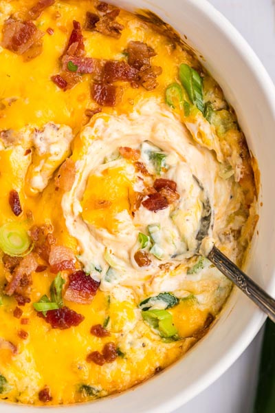 Bacon topped over jalapeno popper dip and sliced green onion.