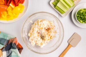 A creamy cheese mixture sitting in a bowl topped with seasoning.