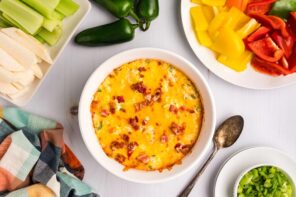 Looking down over jalapeno popper dip with slices of bell pepper, celery and jicama.