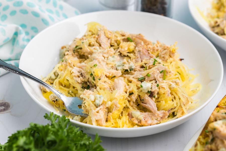 A bowl of spaghetti squash mixed with buffalo chicken and blue cheese.