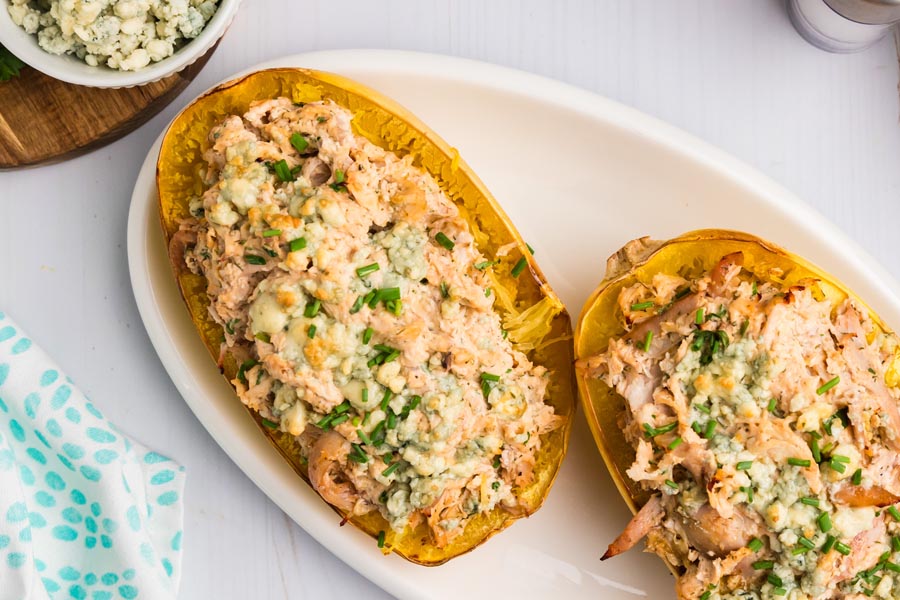 Two spaghetti squash halves stuffed with buffalo chicken mixture.