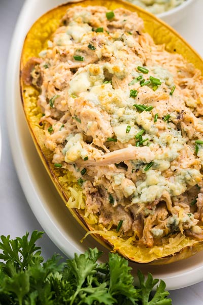 Shredded spaghetti squash filled with buffalo chicken mixture and topped with melted blue cheese and green onion.