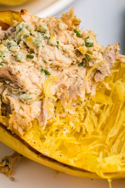 Spaghetti squash noodle strands with buffalo chicken mixture stuffed inside the squash.