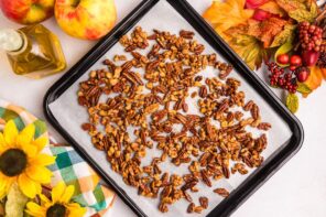 Spiced candied nuts spread out on a baking tray.