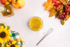 Apple cider vinegar dressing in a measuring cup next to a small whisk.