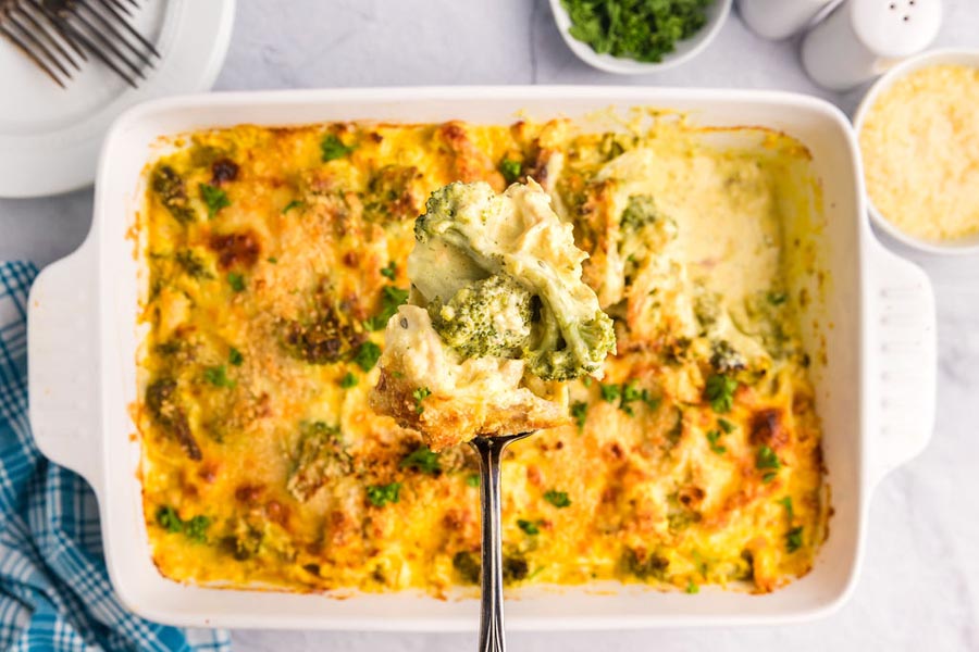 A spoon holding a serving of broccoli chicken casserole