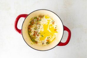 A dutch oven with cream and cooked veggies.