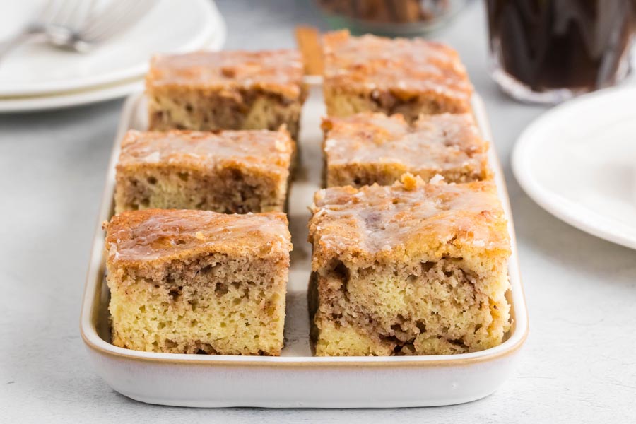 Slices of cinnamon coffee cake on a white tray.