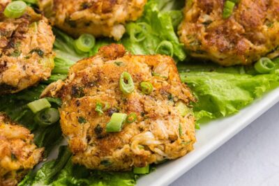 Close up of a crab cake made with fresh crab and topped with green onions.