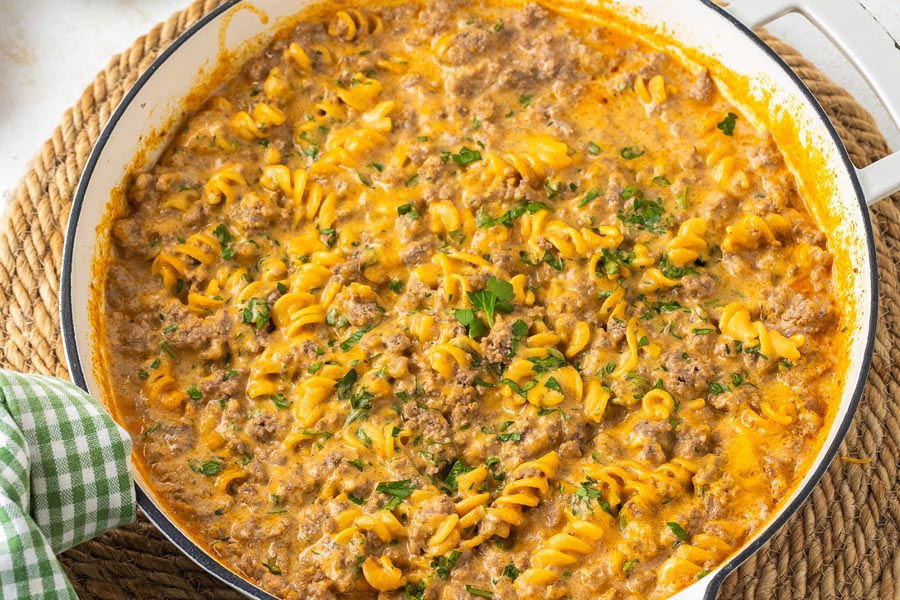 A creamy homemade hamburger helper casserole in a skillet topped with parsley.