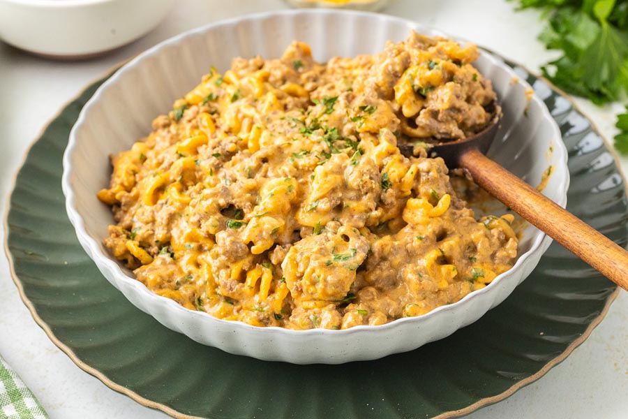 A wooden spoon scooping out a serving of low carb hamburger helper.