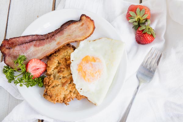 morning breakfast plate with strawberries, eggs bacon and hash browns