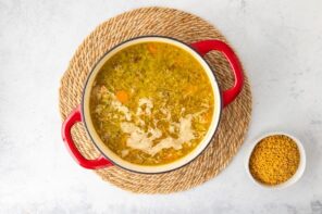 A Dutch oven with soup next to a bowl of lupini pasta rice.