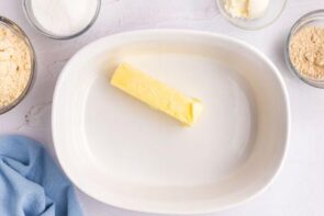 A stick of butter in a white pyrex dish.