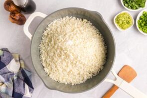 Rice cauliflower cooking inside a skillet.