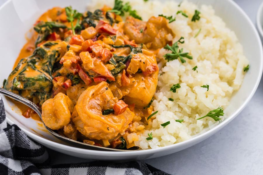 A bowl of paprika shrimp served over cauliflower rice.