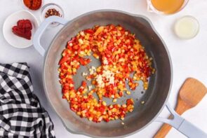 Bell pepper and onion cooking in a skillet.